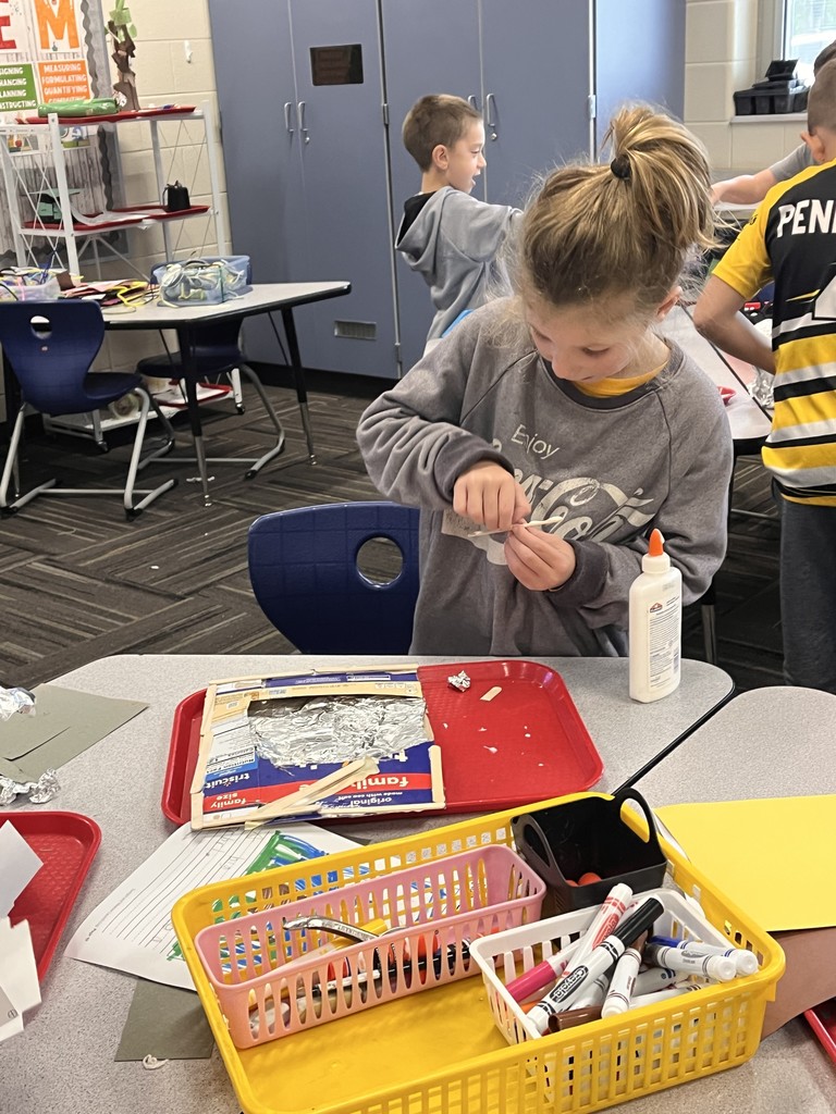 Student desigining a structure with class supplies
