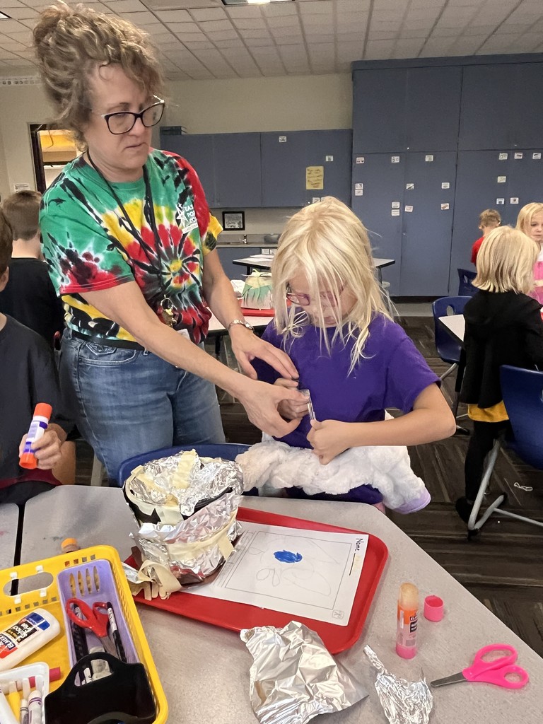 Student desigining a structure with class supplies