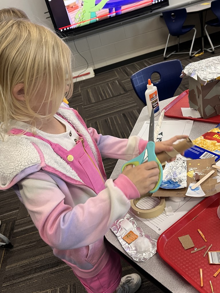 Student desigining a structure with class supplies