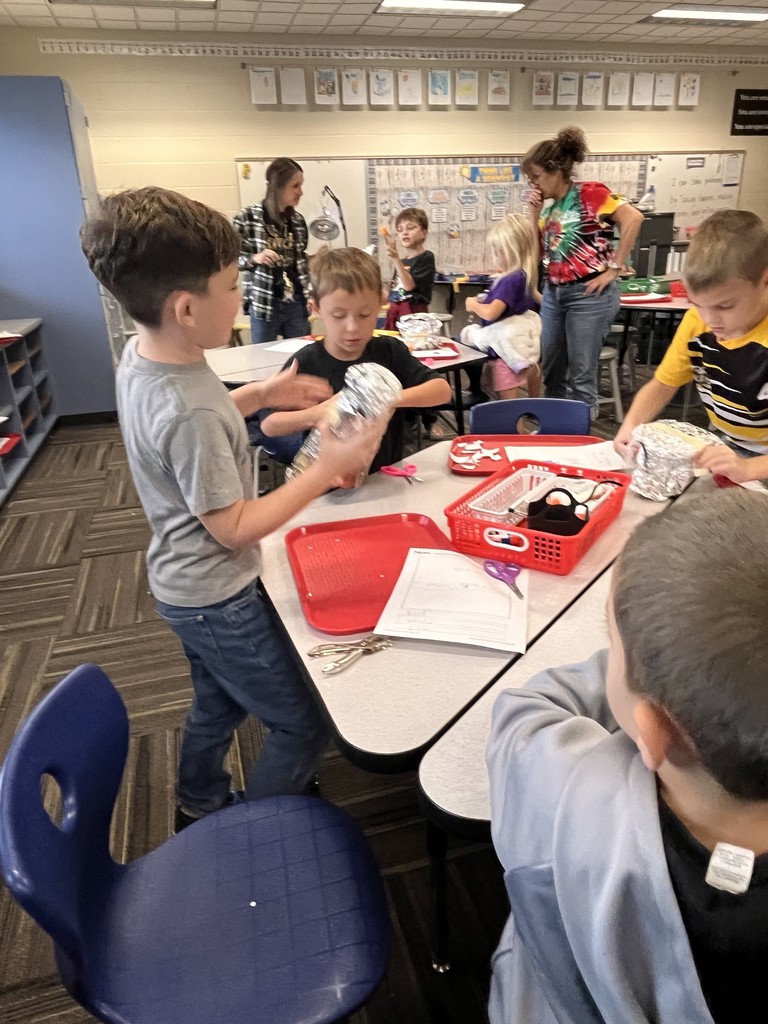 Student desigining a structure with class supplies