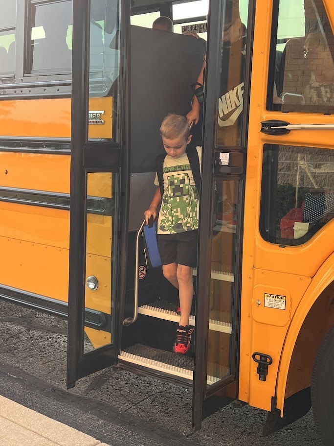 child getting off bus