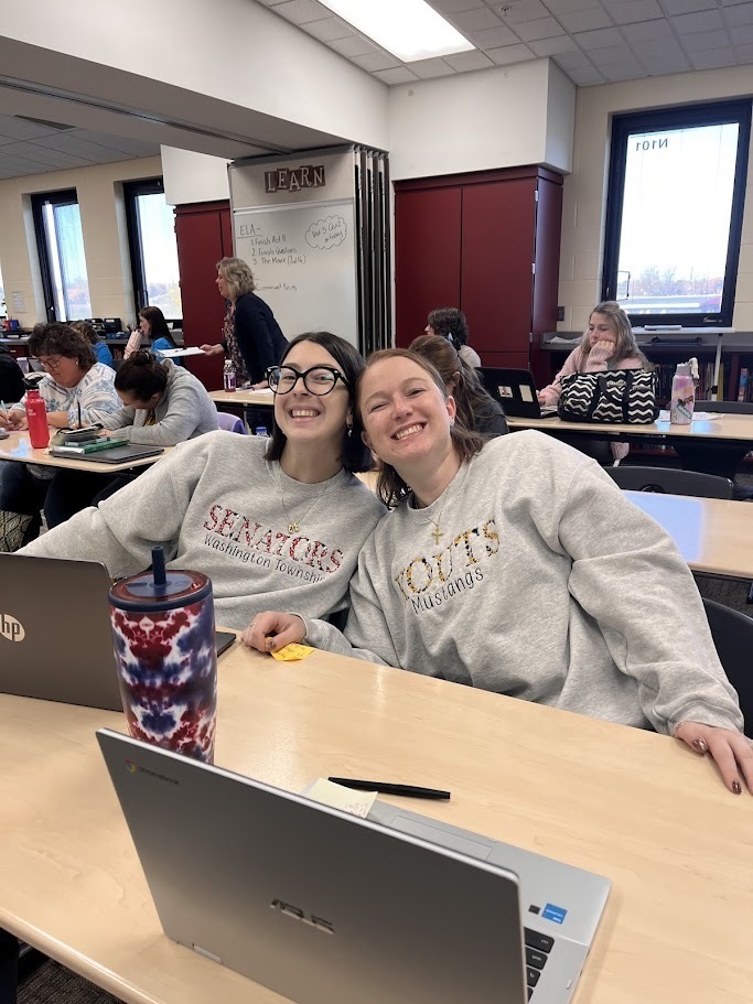 Two teaches smiling one in Kouts shirt and one in Senators shirt