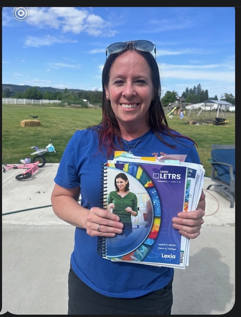 a woman standing and displaying a curriculum book