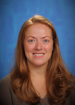 a woman posing in front of a blue backdrop