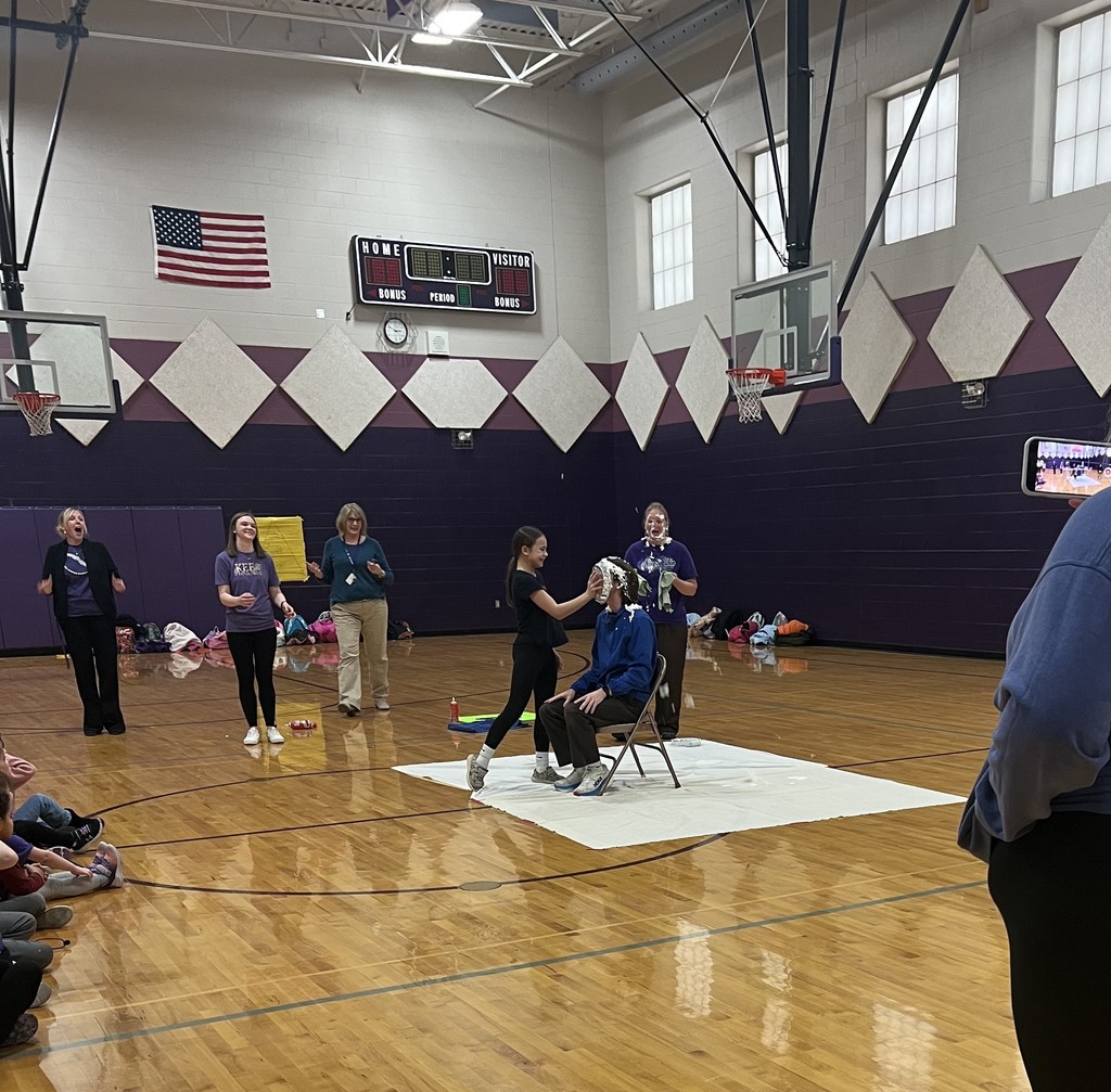 a female student putting a pie in a teachers face