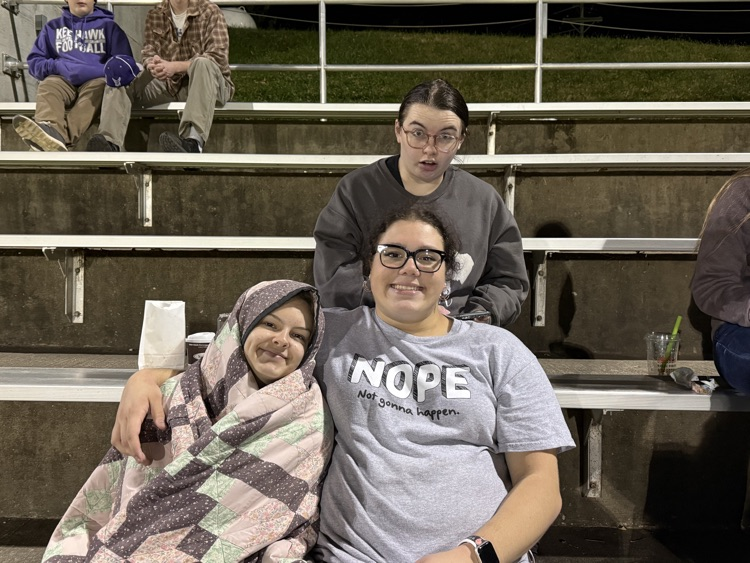 three girls huddled together smiling