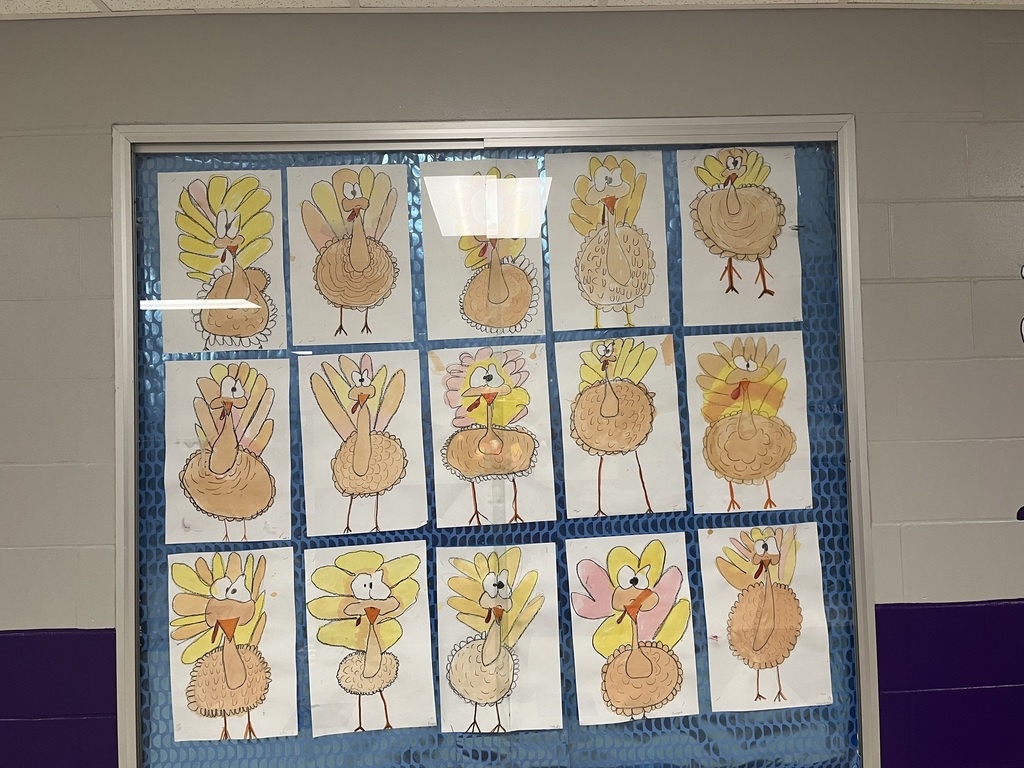 art projects, turkeys, hanging on a bulletin board behind glass. 