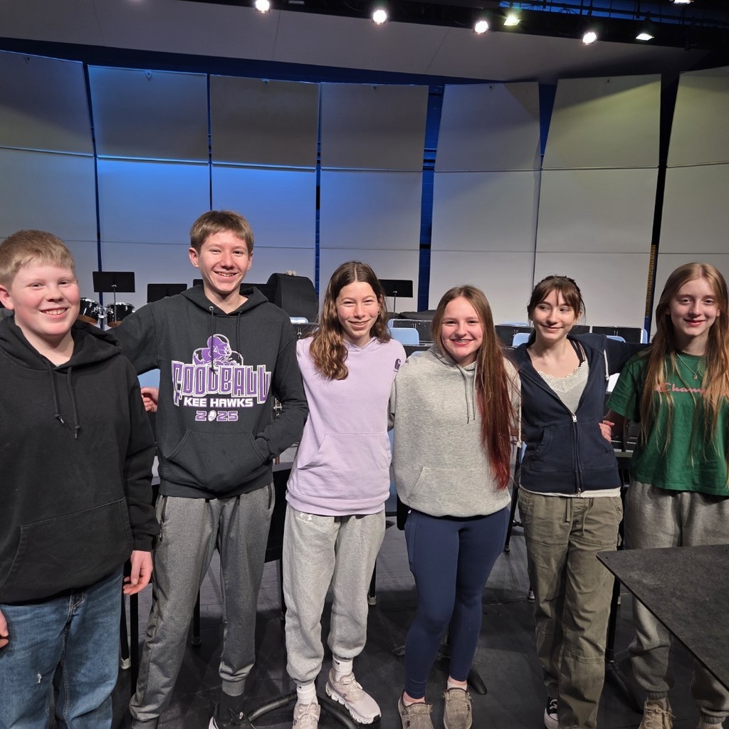 Six students standing in a line and smiling.