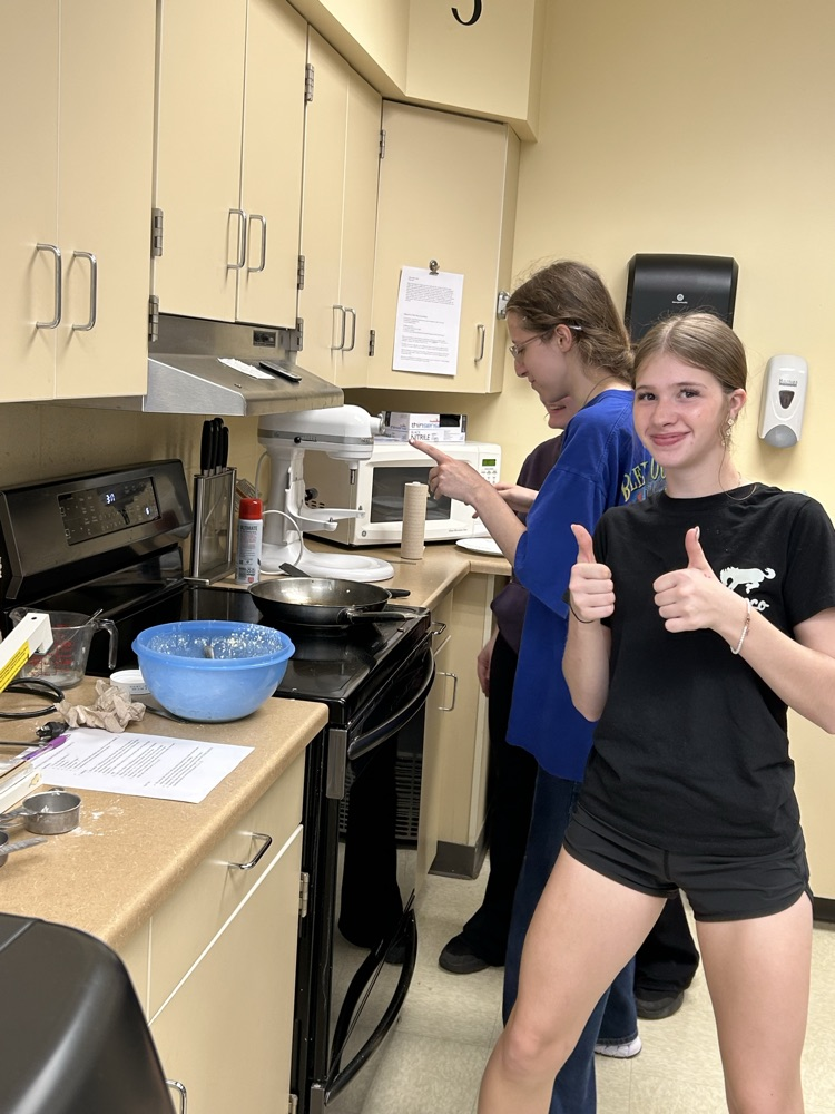 Student cooking and thumbs up