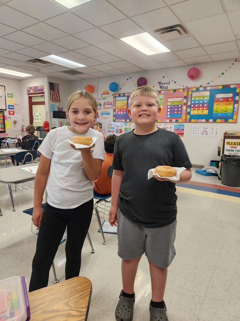 3rd Grade Students Holding Doughnuts
