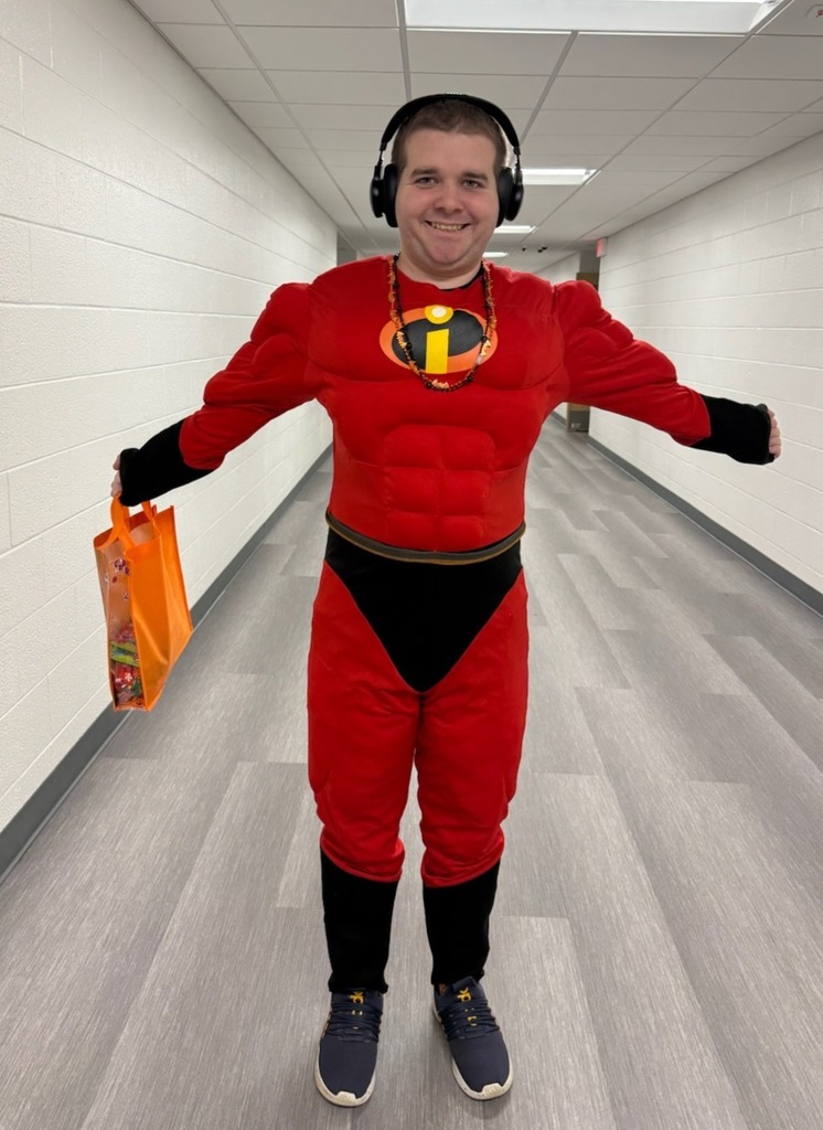 A student stands grinning in an Invincibles costume. 