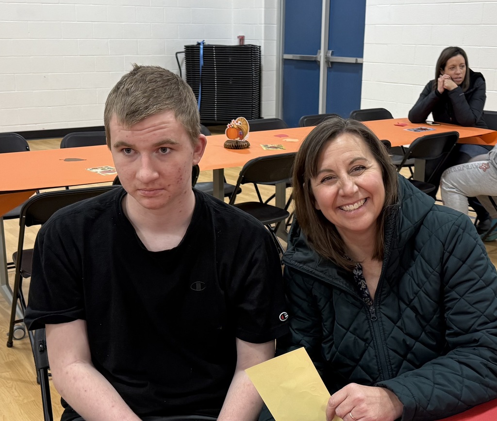 A student and a smiling woman pose for a photo.