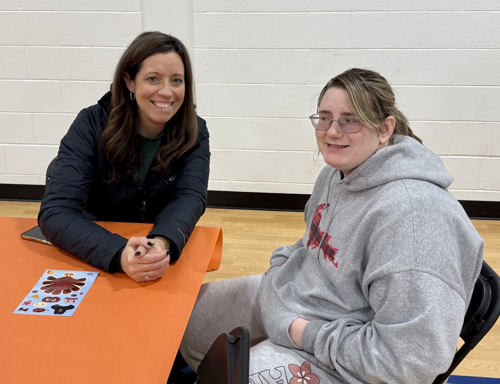 Two smiling guests, one adult and one student smile for the camera.