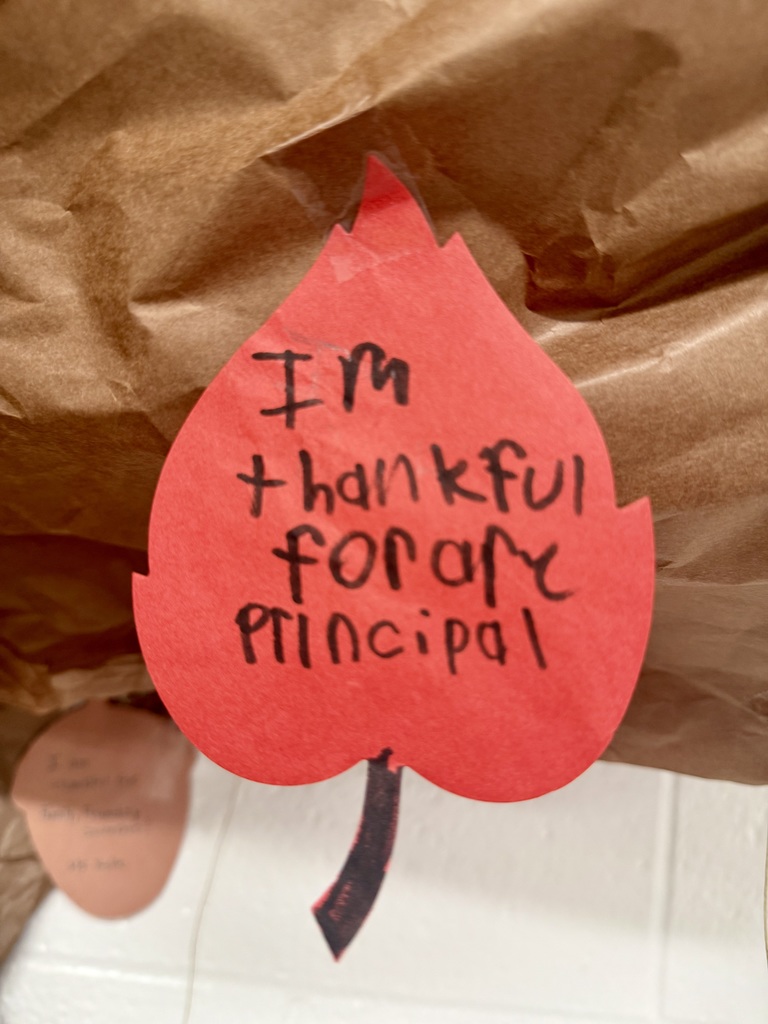 A bright red constuction paper leaf. A child's handwriting reads: "I'm fhankful for are principal."