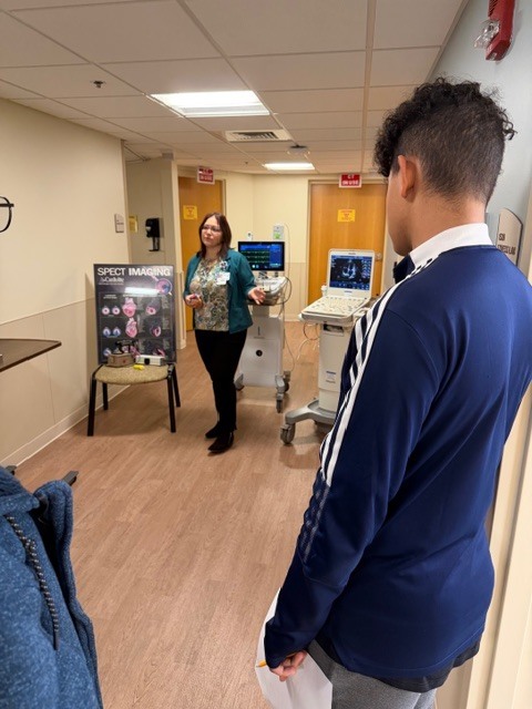 Hospital worker showing students EKG machine