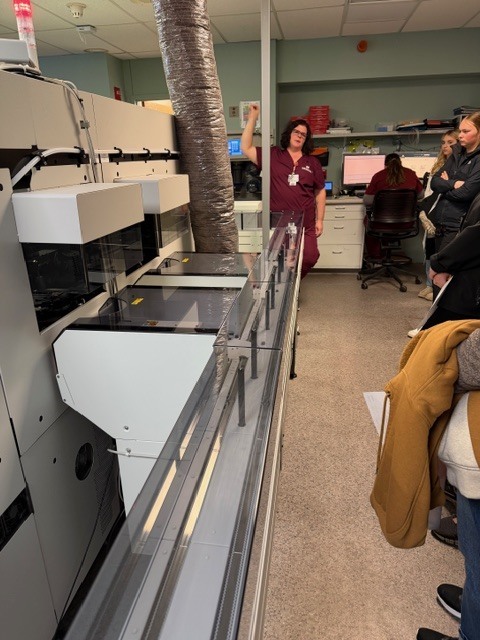 Hospital worker showing students machine in the hospital labratory