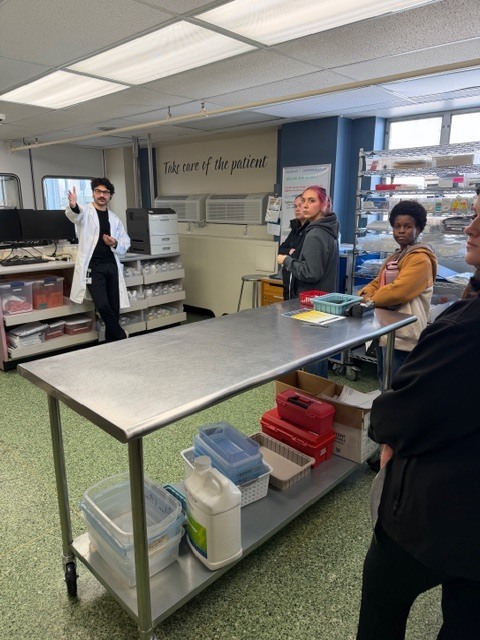 hospital pharmacy worker explaining to students what the role of a pharmacist plays in the hospital setting