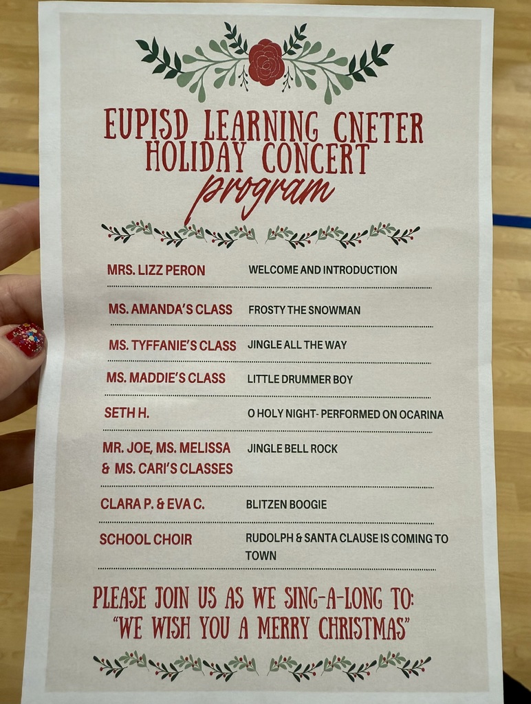 A picture of the holiday concert program in a festive red and green design. It lists the teacher/class name and what song they will be performing. 