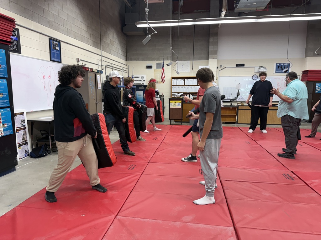 group of students on red mat practicing defensive skills