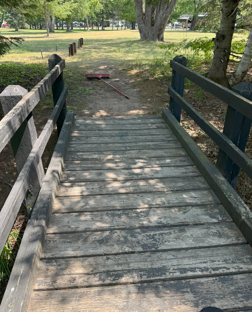A wooden bridge with most of the paint worn off.