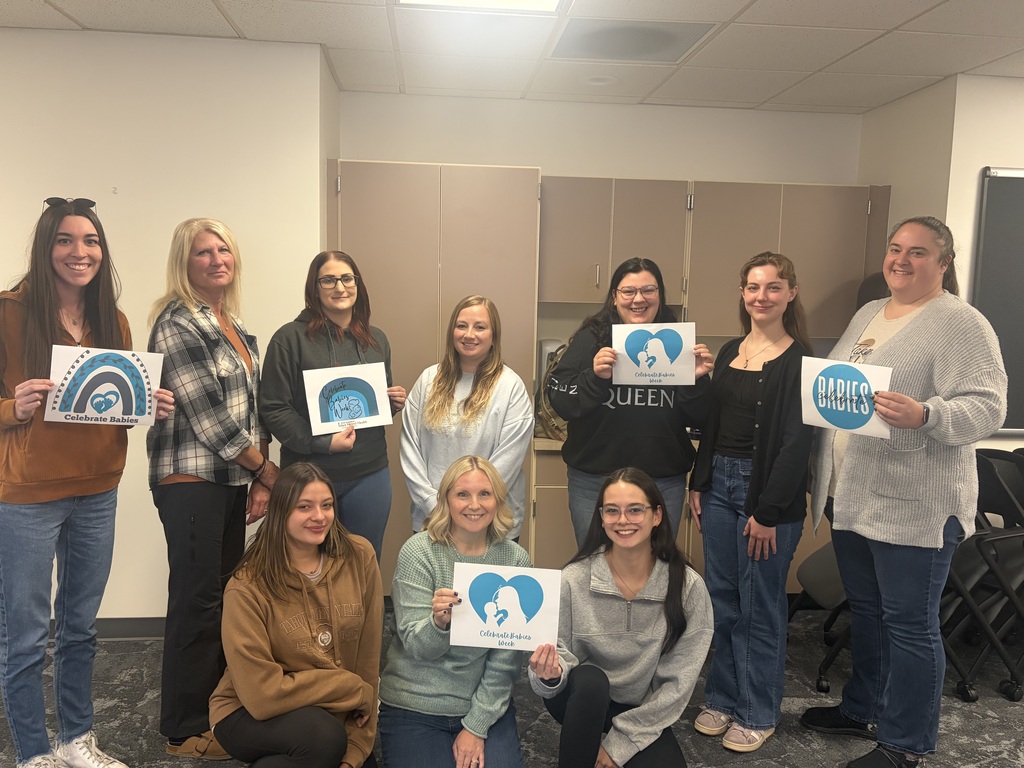 photo includes 10 women with every other woman holding a logo for celebrate babies week.