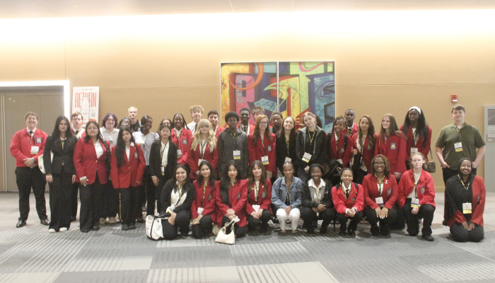 Students from the Eastland-Fairfield Career & Technical Schools SkillsUSA chapter pose together during the 2026 SkillsUSA Ohio State Championships. The group, many wearing red SkillsUSA jackets and conference badges, stands and kneels in a hotel or convention center lobby during the state competition.