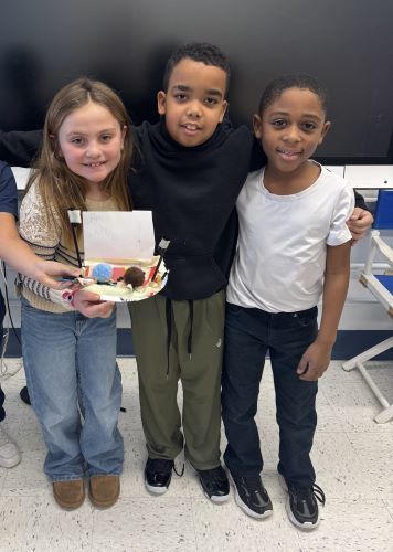 Second grade students showing their "Things That Go Places" creation. 