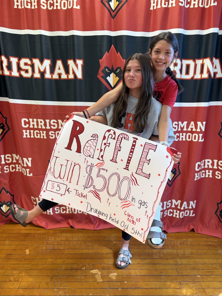 Freshmen Claire and Willa hold  raffle ticket signs