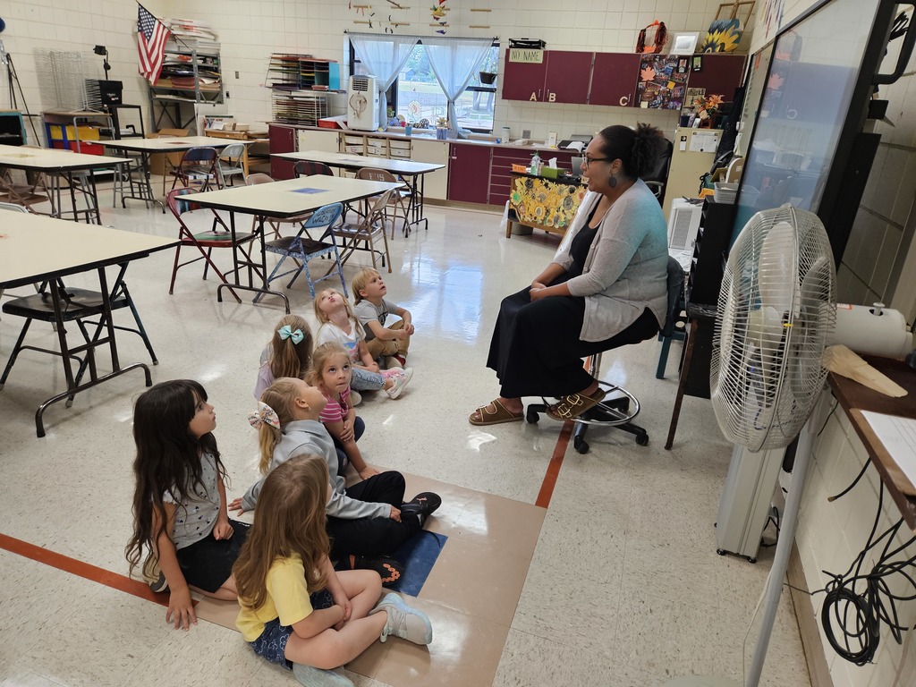 7 kids sitting in front of an art teacher