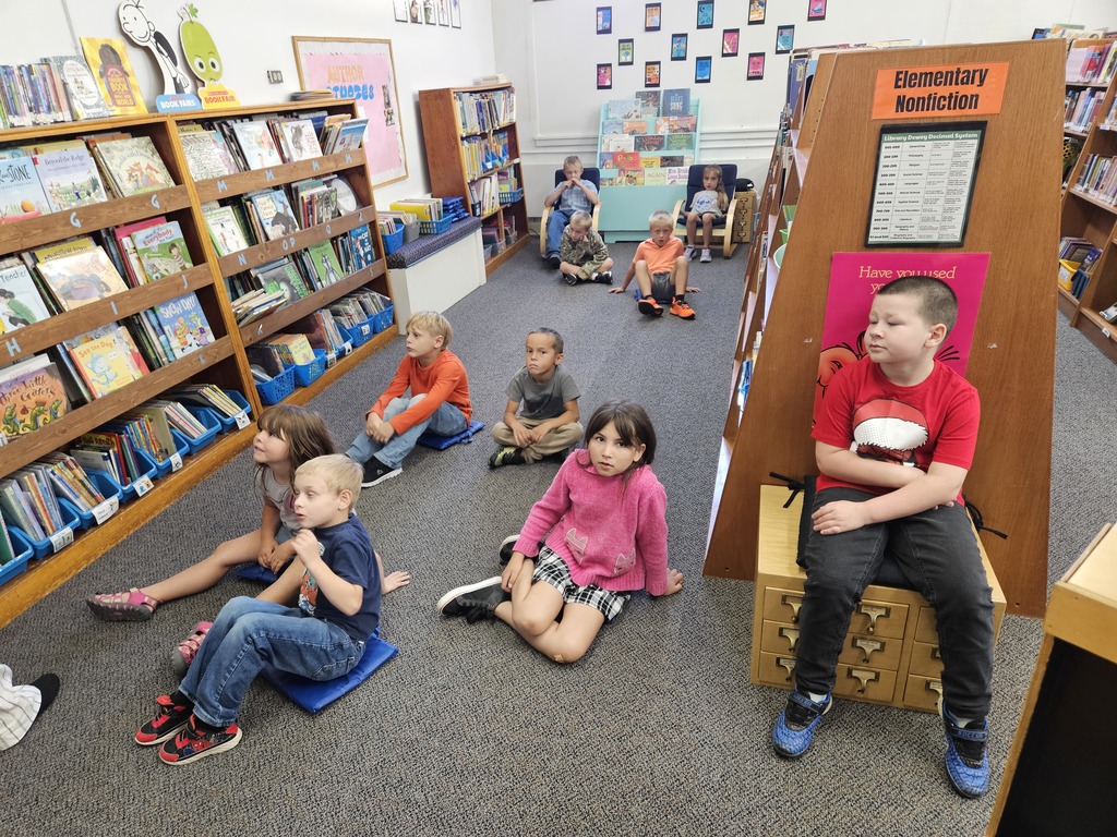 10 kids sitting in a library