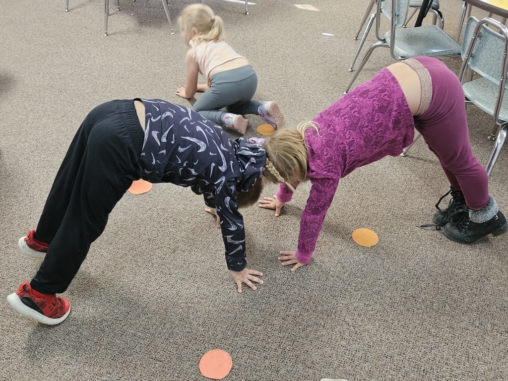 Two kids making two arches to look like the letter m