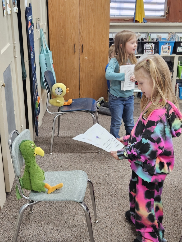2 girls reading to stuffed animals 