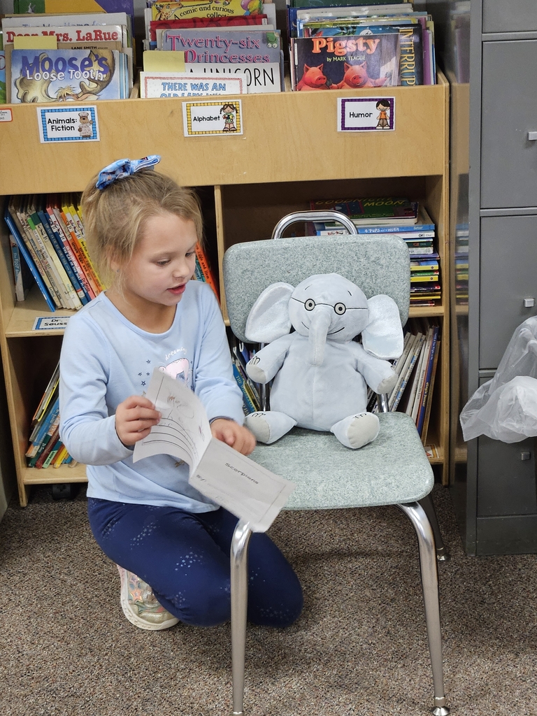 a girl reading to stuffed animal