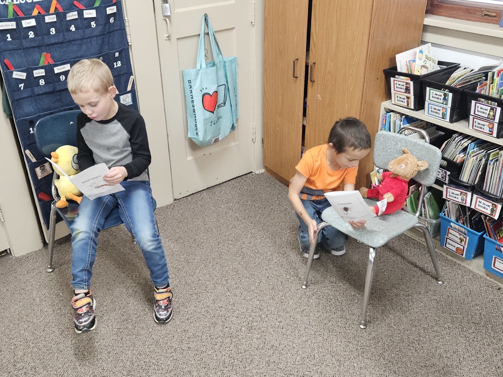 2 boys reading to stuffed animals