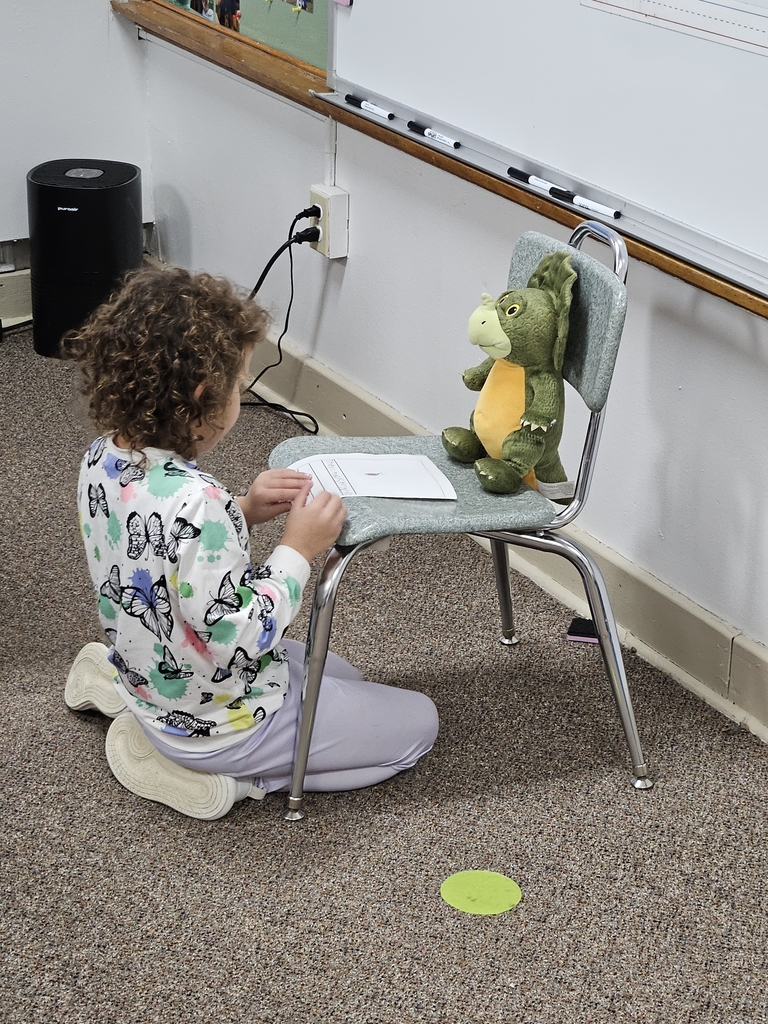 a girl reading to stuffed animal