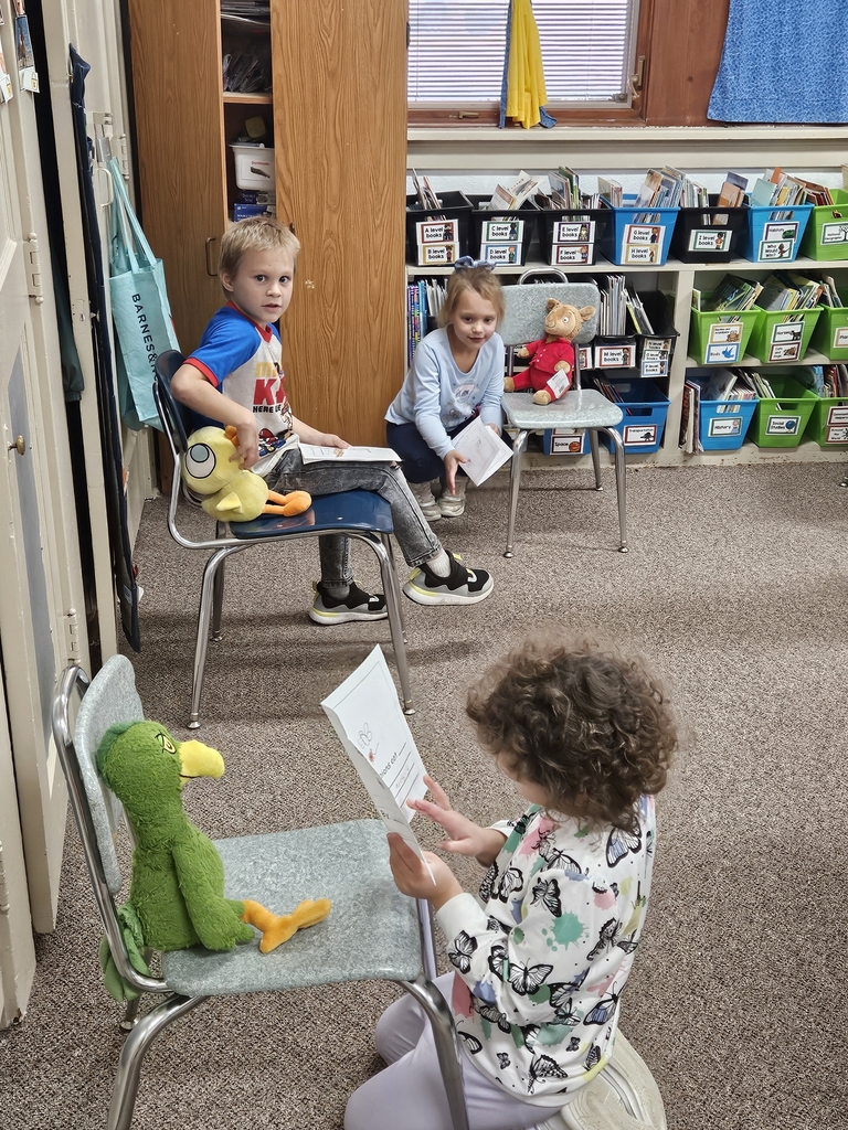 2 kids reading to stuffed animals