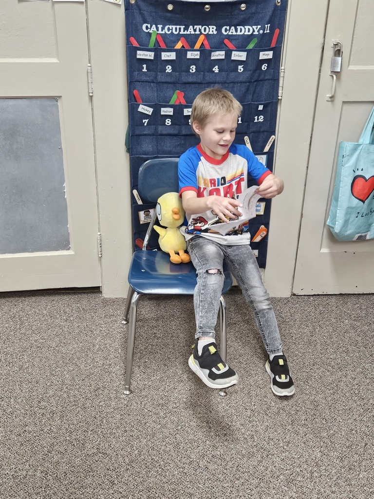 a boy reading to stuffed animal