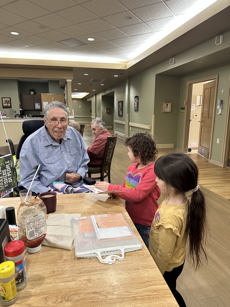 Two girls reading to a man