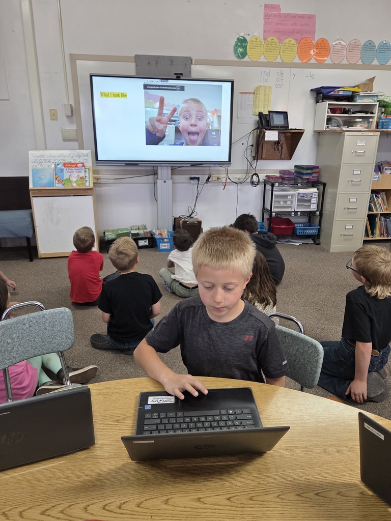 10 kids looking at a big screen
