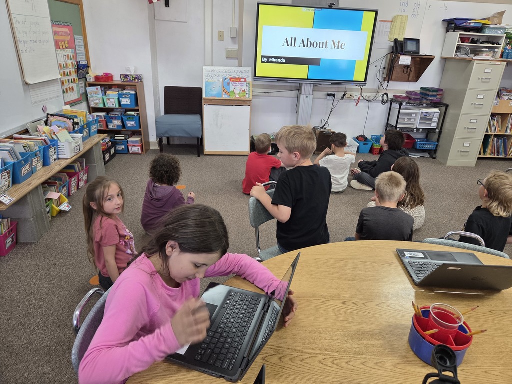 10 kids looking at a big screen