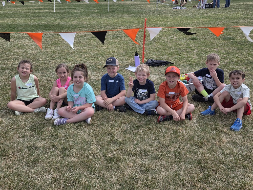 8 kids sitting in the grass