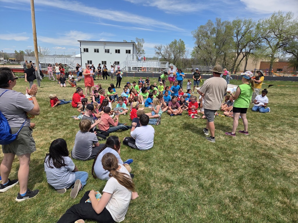 a crowd of kids sitting in the grass