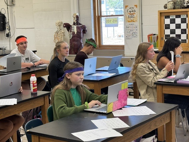students with Teenaged Mutant Ninja Turtles headbands sitting at tables in a classroom