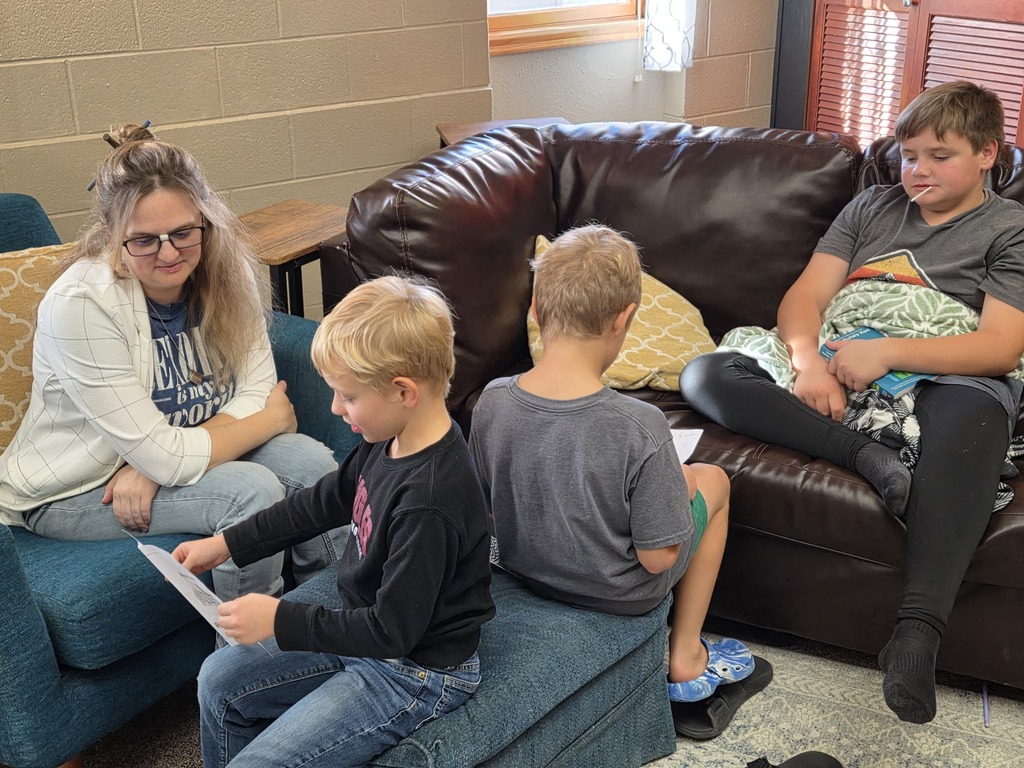 3 kids and a teacher reading together