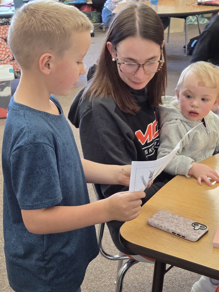 a kid, a teacher, and a toddler reading together