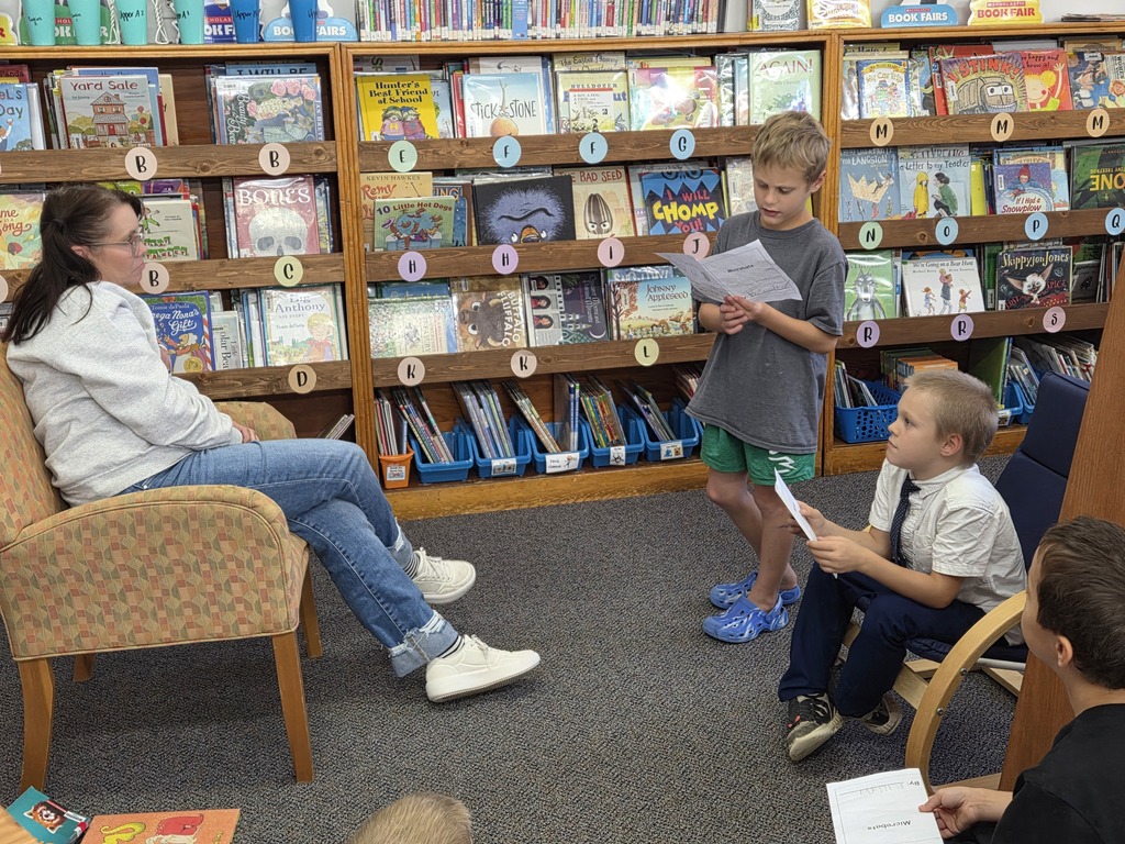3 kids and a teacher reading together