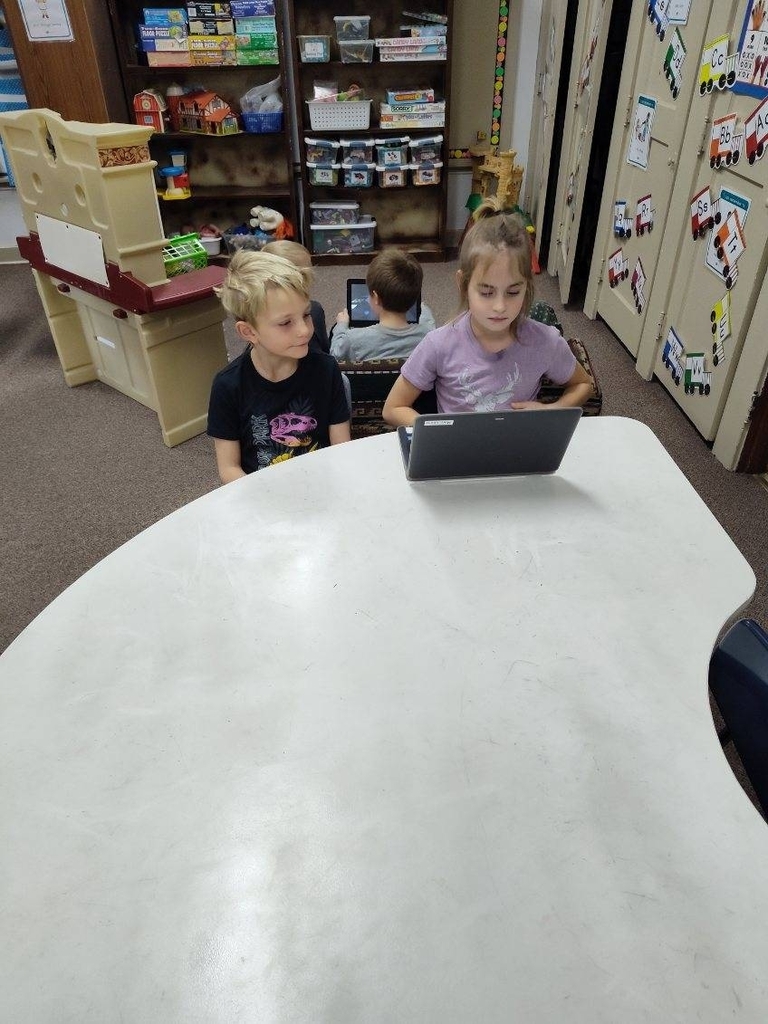 two kids looking at a computer 