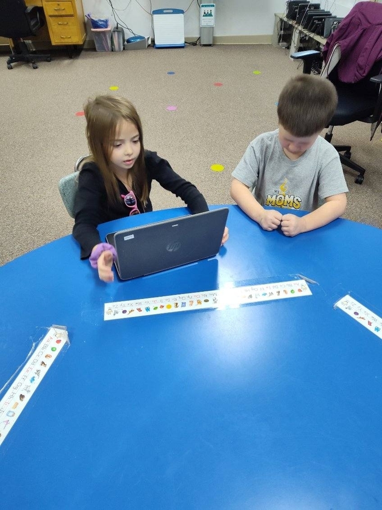 2 kids looking at a computer 