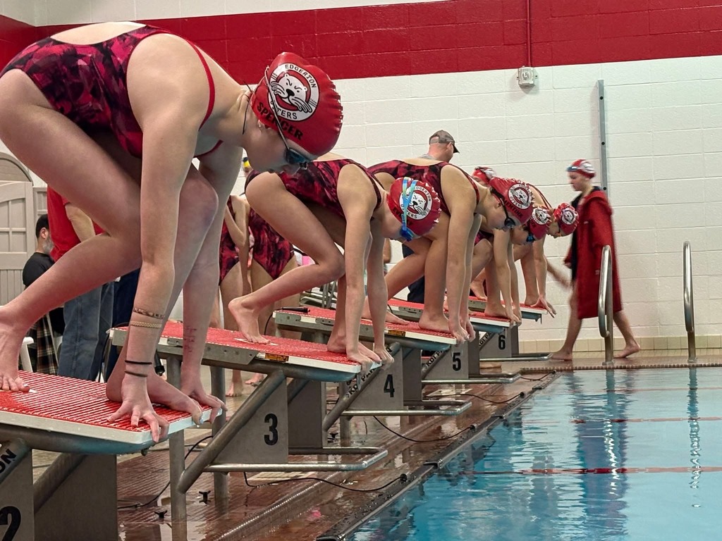 Swimmers on the block ready to start.