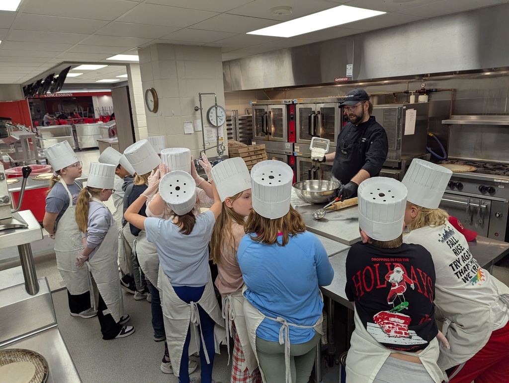Students watching chef Ben create pizza dough.